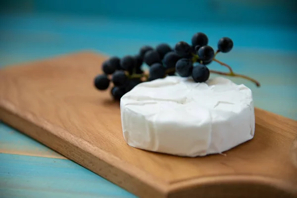 Camembert de queijo no fundo de madeira azul vista superior — Fotografia de Stock
