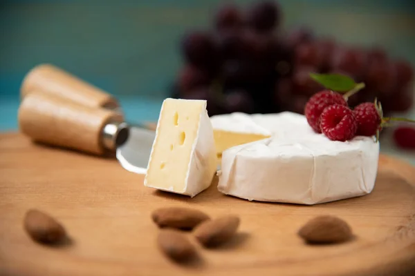 Camembert queijo com framboesas e uvas em — Fotografia de Stock