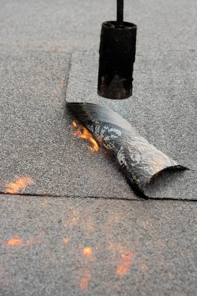 Preheating the edges of the roofing material.