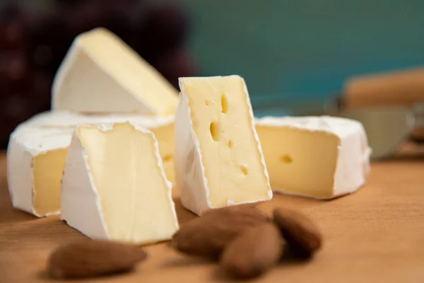 Сыр камамбер или бри на синем деревянном фоне — стоковое фото