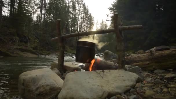 Kochen von Essen im Topf über dem Lagerfeuer — Stockvideo