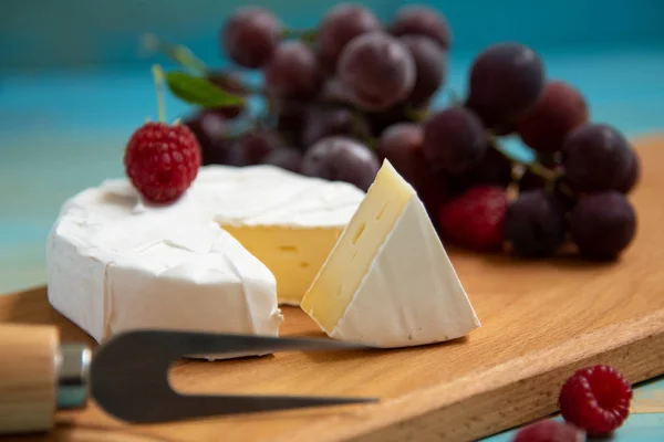 Camembert queijo com framboesas e uvas em — Fotografia de Stock