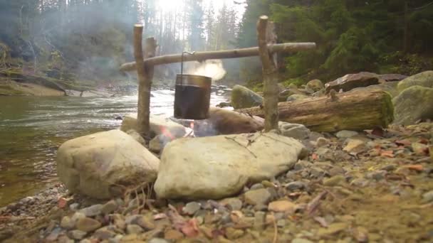 Cucinare il cibo in pentola sul falò — Video Stock