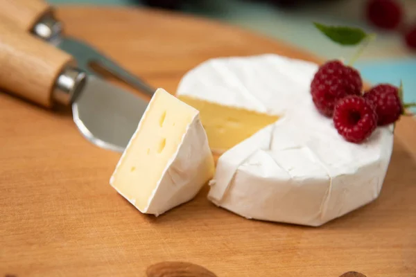 Camembert de queijo com framboesas e nozes na mesa — Fotografia de Stock