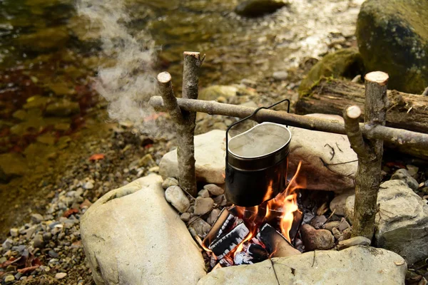 Cooking food in pot over campfire outdoor