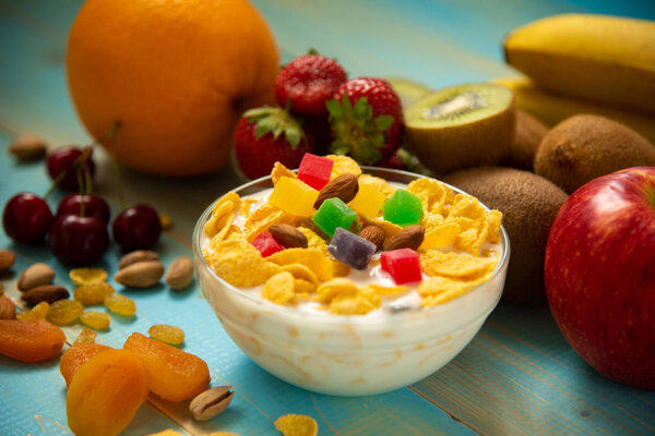 Tasty cornflakes with milk and fruits  in glass bowl 