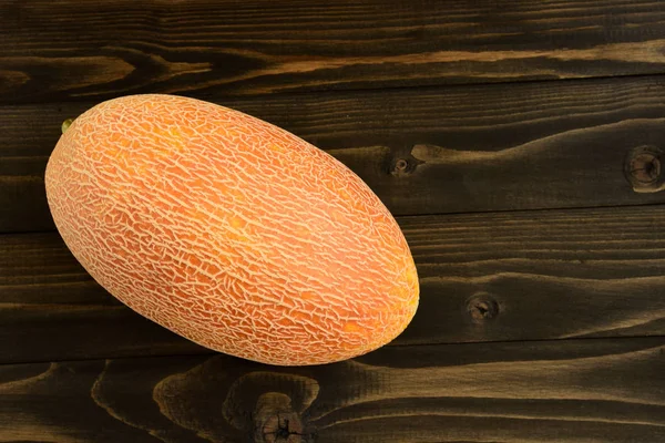 Melones frescos sobre una vieja mesa de madera negra — Foto de Stock