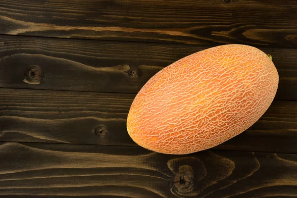 Melones frescos sobre una vieja mesa de madera negra — Foto de Stock