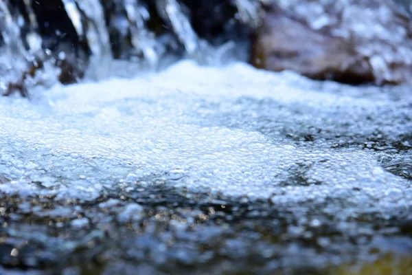 Superficie de agua con ondas y reflejos de rayos solares — Foto de Stock