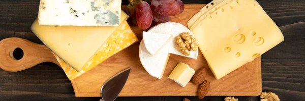 Různé druhy sýrů na rustikální stůl — Stock fotografie