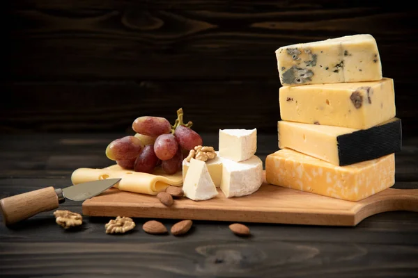 Różne rodzaje sera na rustykalne tabela — Zdjęcie stockowe