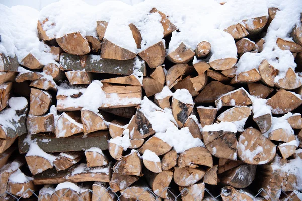 Brennholzvorrat unter Schnee im Freien Stockfoto