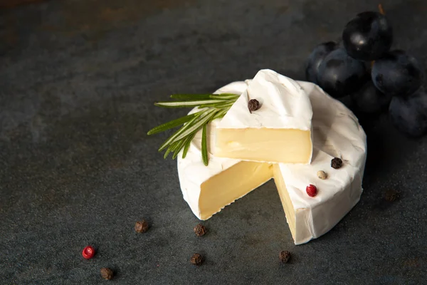 Cheese camembert or brie with dark grapes