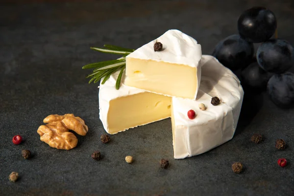 Camembert de queijo ou brie com uvas escuras — Fotografia de Stock