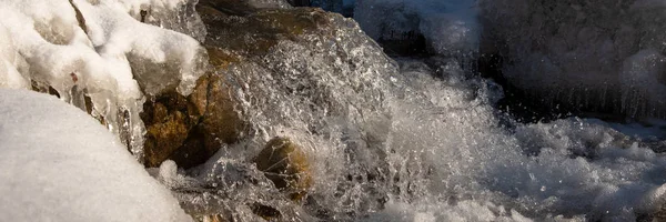 Water flowing in rapids over stone, in the winter mountains — Stock Photo, Image