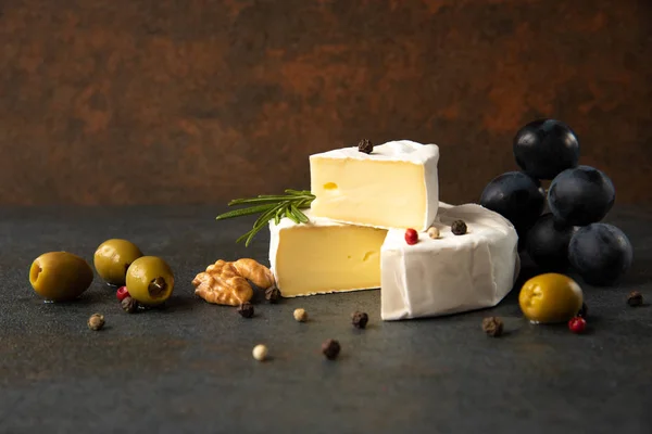 Camembert de queijo ou brie com azeitonas e uvas — Fotografia de Stock