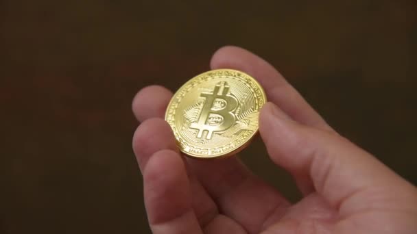 Man hand houden goud bitcoin — Stockvideo