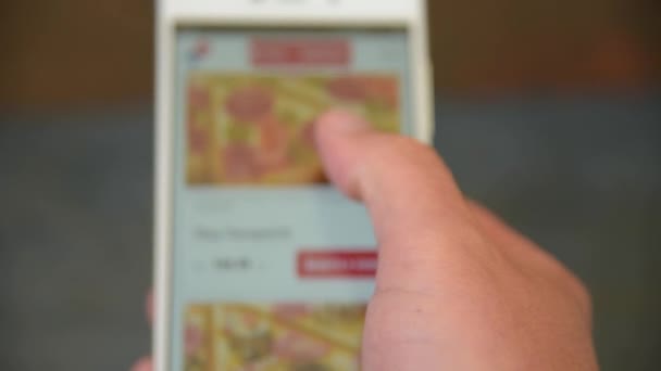 一个男人在智能手机上寻找和选择比萨饼 — 图库视频影像