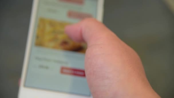 Bir adam arıyor ve akıllı telefonda pizza seçer — Stok video