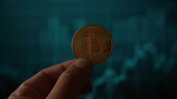 Mano del hombre sosteniendo una moneda de oro bitcoin — Vídeo de stock