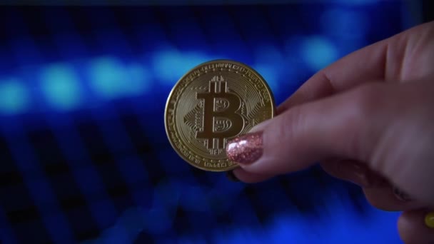 Kvinnlig hand som håller ett guldmynt bitcoin — Stockvideo