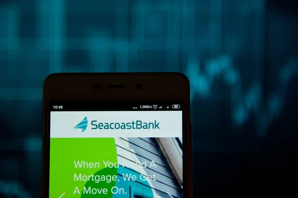 Ivano-frankivsk, Ukraine - 15. Mai 2019: Meeresufer mit Florida-Logo ist auf einem Smartphone über dem Aktiendiagramm zu sehen. Meeresufer von Florida-Logo wird auf dem Bildschirm eines mobilen Geräts angezeigt. — Stockbild Meeresufer von Florida Logo auf dem Smartphone gesehen — Stockfoto