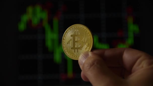 Ember kezében egy arany érme Bitcoin — Stock videók