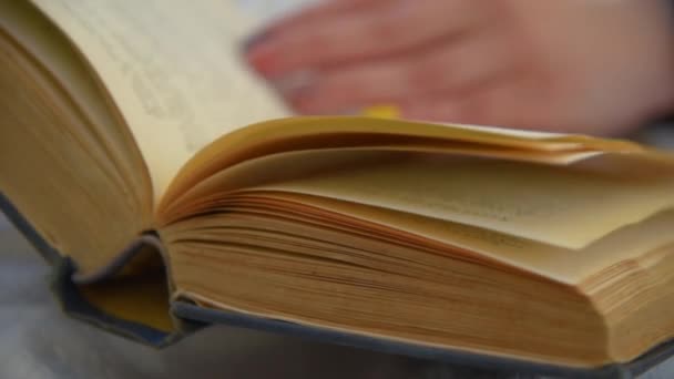 Une main de femme retourne les pages 