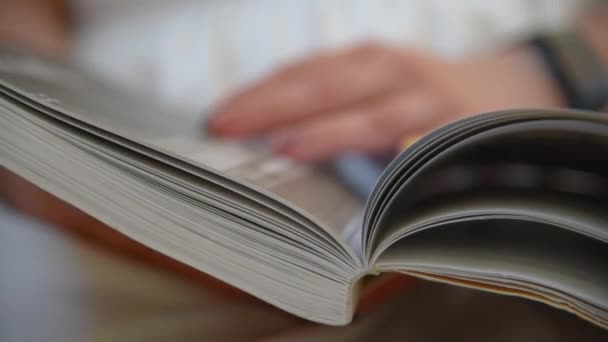 A womans hand turns over the pages — Stock Video