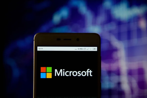 Ivano-frankivsk, Ukraine - 13. Mai 2019: Das Firmenlogo von microsoft ist auf einem Android-Mobiltelefon über dem Aktiendiagramm zu sehen. microsoft corporation logo wird auf dem Bildschirm eines mobilen geräts angezeigt. — Stockbild Microsoft-Firmenlogo auf dem Smartphone — Stockfoto