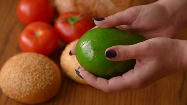 Женщина открывает авокадо в двух частях — стоковое видео