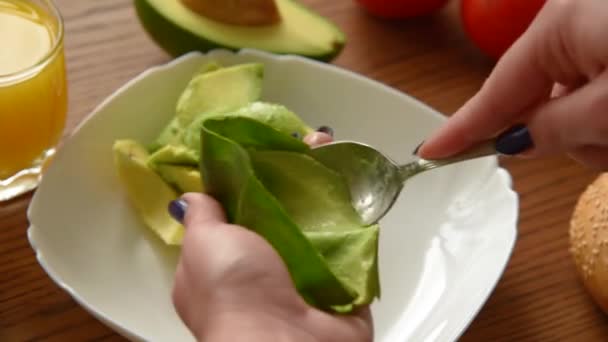 Kvinna som öppnar en avokado i två delar — Stockvideo