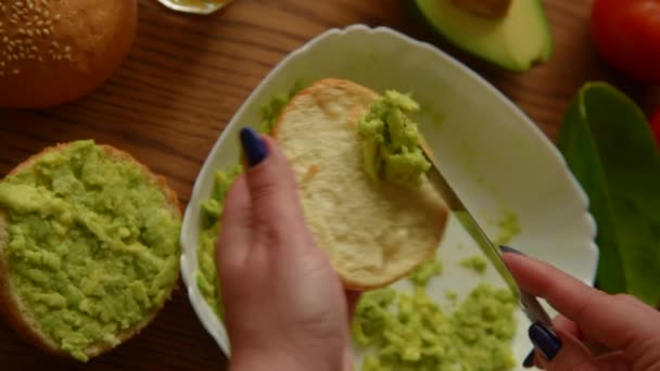 Жінка розклала авокадо на підсмажений бутербродний хліб — стокове відео