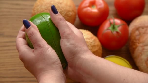 Vrouw het openen van een avocado in twee delen — Stockvideo