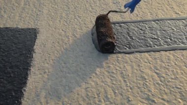 İşçi temel üzerine bitumen mastic uygular