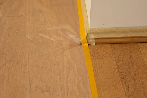 Oak floor covered with transparent plastic film — Stock Photo, Image