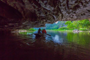 Turistler, sivil toplum örgütü Dong Nehri boyunca tekne seyahat ve Tam Coc resim çekmek itmek için ayak kullanarak kürekçi kürek, Tam Coc, Ninh Binh, Vietnam.
