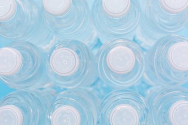 Doğal beyaz arka planda plastik şişe suda serinletici satırları üzerinde üstten görünüm.