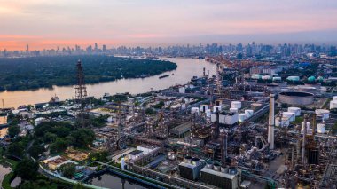 Havadan görünümü Petrokimya sanayi petrol rafinerisi şehir arka plan ile gün batımında.