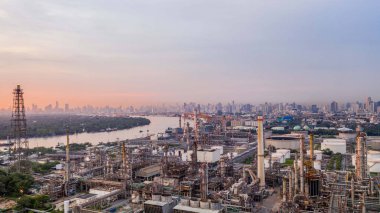 Havadan görünümü Petrokimya sanayi petrol rafinerisi şehir arka plan ile gün batımında.