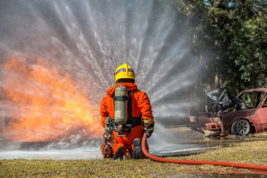 Söndürücü ve su hortum dan yangınla mücadele için kullanarak kopya alanı ile ateş için yüksek basınçlı su püskürtme itfaiyeci itfaiyeci.
