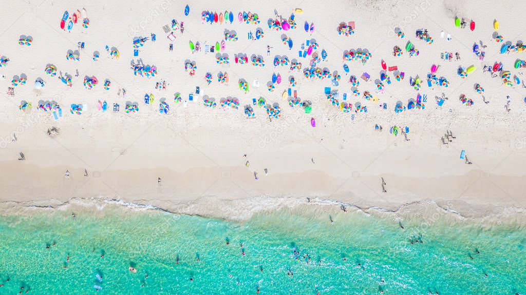 Aerial view Tropical white sand beach with azure clear water, umbrella and lush greenery. Top view. Aerial shooting of Phuket beach, Phuket, Thailand.