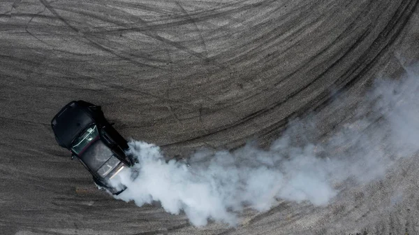 Havadan görünüşlü araba sürüklenen difüzyon yarışı hız yolunda yanan lastiklerden çıkan dumanla sürüklenen araba profesyonel sürücünün sürücüsü beyaz dumanla sürüklenen araba. .