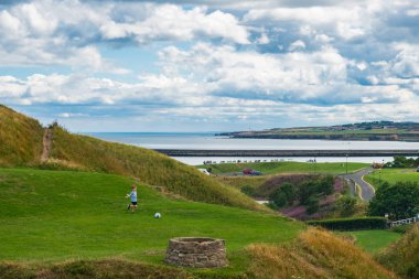 Tynemouth, İngiltere - 2 Ağustos 2018: mutlu Tynemouth tarikat ve kale yakınında futbol oynarken bir çocuk.
