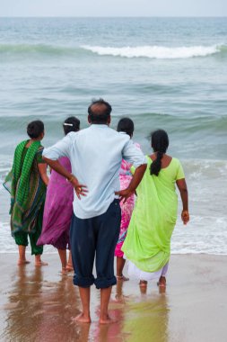 Chennai, Hindistan - 6 Eylül 2007: Bir adam ve dört kadın, yalınayak, popüler Marina Beach Chennai kaba denize doğru bakıyor