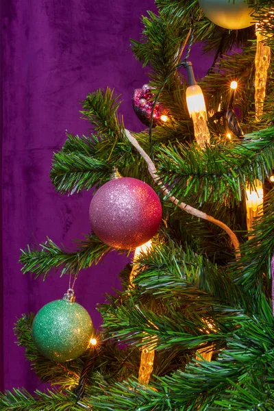 顕著な装飾ハンギング ボールとキャンドル ライトで紫をテーマにクリスマス ツリーが飾られて — ストック写真