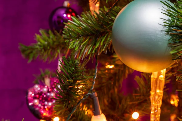 著名なシアン ボールとフォア グラウンドで目の前でろうそくが紫色のテーマで装飾されたクリスマス ツリー — ストック写真