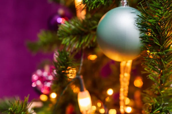 フォア グラウンドとバック グラウンドでキャンドル ライトを含む他の装飾で顕著なシアン ボールで紫をテーマに飾られたクリスマス ツリー — ストック写真