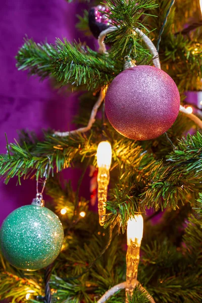 顕著な装飾的な紫と水色と紫をテーマに飾られたクリスマス ツリーのクローズ アップのボールと目の前でキャンドル ライト — ストック写真