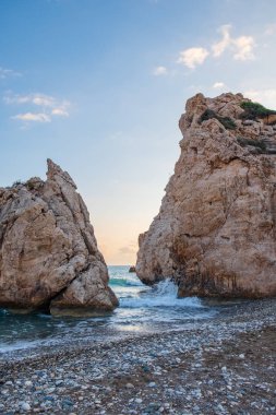 Petra tou Romiou, Paphos, Kıbrıs için çevresinde çakıllı plaj dalgalar breaking öğleden sonra Görünüm. Yunan mitolojisinde Afrodit'ın Doğum yeri olarak kabul edilir.
